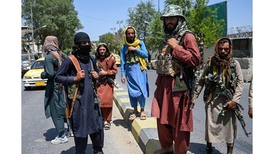 Taliban fighters stand guard along a street near the Zanbaq Square in Kabul on August 16.&nbsp; (Wakil Kohsar / AFP)