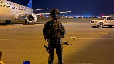 A US army soldier stands guard as Afghans wait to leave from the airport in Kabul (AFP) A US army soldier stands guard as Afghans wait to leave from the airport in Kabul (AFP)