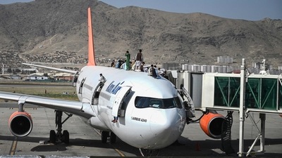 People climb atop a plane as they wait at the Kabul airport on Monday to flee Afghanistan, (AFP) People climb atop a plane as they wait at the Kabul airport on Monday to flee Afghanistan, (AFP)