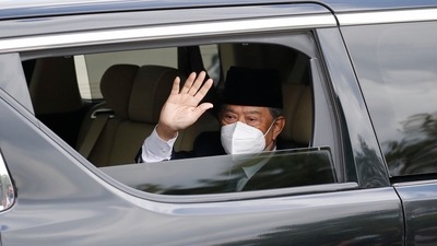 Embattled Malaysian Prime Minister Muhyiddin Yassin waves from a car while entering the National Palace to meet with the King in Kuala Lumpur, Malaysia. (AP) Embattled Malaysian Prime Minister Muhyiddin Yassin waves from a car while entering the National Palace to meet with the King in Kuala Lumpur, Malaysia. (AP)