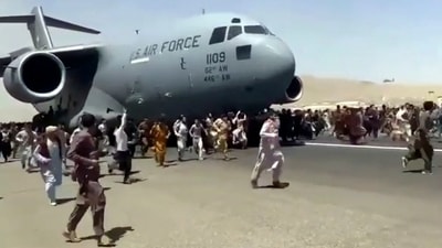 Hundreds of people run alongside a US Air Force C-17 transport plane as it moves down a runway of the international airport, in Kabul, Afghanistan, on Monday, (AP)