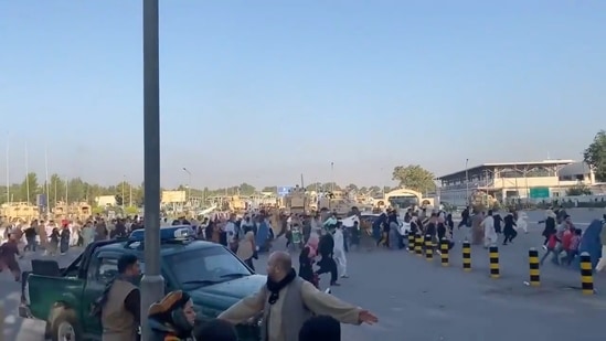 A horde of people run towards the Kabul Airport Terminal, after Taliban insurgents took control of the presidential palace in Kabul.(Reuters)