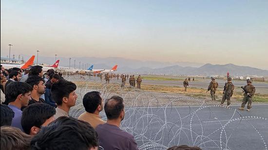 Afghan crowd at the Kabul airport as US soldiers stand guard on August 16. (AFP)