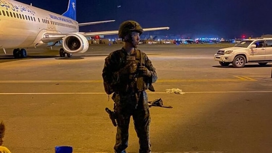 A US army soldier stands guard as Afghans wait to leave from the airport in Kabul(AFP)