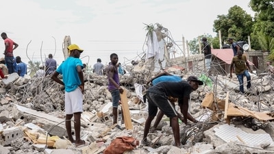 Residents search for valuable metals in the rubble of a collapsed hotel in Les Cayes, Haiti, (Bloomberg) Residents search for valuable metals in the rubble of a collapsed hotel in Les Cayes, Haiti, (Bloomberg)