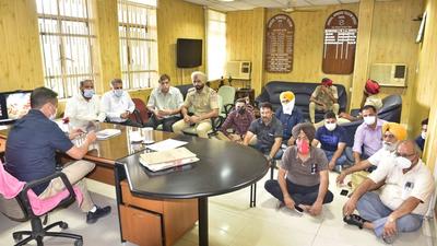 BSNL employees sitting on the floor during a protest over transfers, inside the GM office in Ludhiana on Tuesday. (Gurpreet Singh/HT)