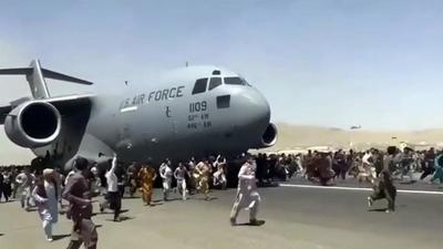Hundreds of people run alongside a U.S. Air Force C-17 transport plane as it moves down a runway of the international airport, in Kabul, Afghanistan, Monday. (AP) Hundreds of people run alongside a U.S. Air Force C-17 transport plane as it moves down a runway of the international airport, in Kabul, Afghanistan, Monday. (AP)