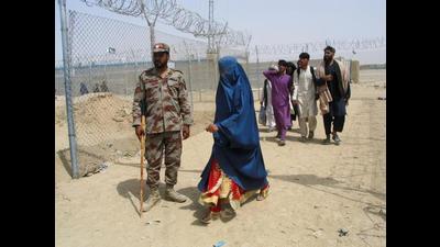 An Afghan woman walking past a Pakistani paramilitary personnel, as she along with others enter Pakistan via Friendship Gate crossing point at the Pakistan-Afghanistan border town of Chaman on Tuesday. (Reuters) An Afghan woman walking past a Pakistani paramilitary personnel, as she along with others enter Pakistan via Friendship Gate crossing point at the Pakistan-Afghanistan border town of Chaman on Tuesday. (Reuters)