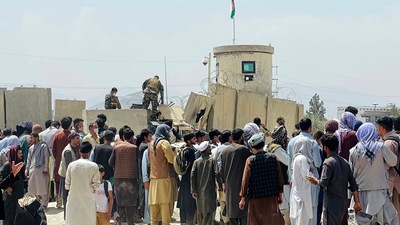 Kabul: Afghan security guards stand on a wall as hundreds of people gather outside the international airport in Kabul, Afghanistan, Tuesday. (AP) Kabul: Afghan security guards stand on a wall as hundreds of people gather outside the international airport in Kabul, Afghanistan, Tuesday. (AP)