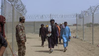 A Pakistani paramilitary soldier stands guard as people enter Pakistan through a border crossing point, in Chaman, Pakistan, Tuesday. (AP) A Pakistani paramilitary soldier stands guard as people enter Pakistan through a border crossing point, in Chaman, Pakistan, Tuesday. (AP)