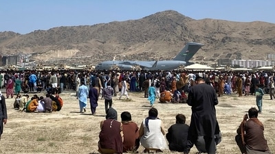 Hundreds of people gather near a US Air Force C-17 transport plane at a perimeter at the international airport in Kabul, Afghanistan, Monday, Aug. 16, 2021. (AP)