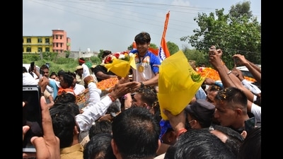Neeraj was given a warm welcome in Khandra village of Panipat. Youths carrying Tricolours were seen chasing his vehicle on motorbikes and cars. (HT Photo) Neeraj was given a warm welcome in Khandra village of Panipat. Youths carrying Tricolours were seen chasing his vehicle on motorbikes and cars. (HT Photo)