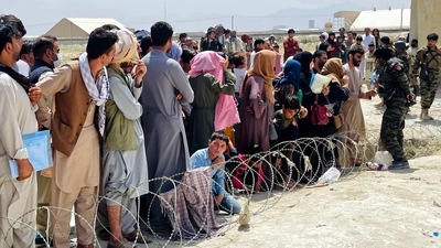 Afghan security guards try to maintain order as hundreds gather outside the international airport in Kabul, Afghanistan on Tuesday. (AP)