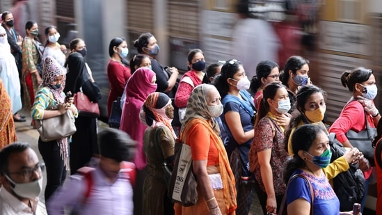 Commuters wearing protective face masks wait to board a suburban train after authorities resumed train services for vaccinated passengers from August 15.(REUTERS)