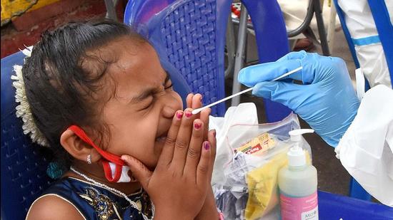 A healthcare worker collects a swab sample of a baby for the Covid-19 test at City Railway Station, in Bengaluru on Friday. (ANI)