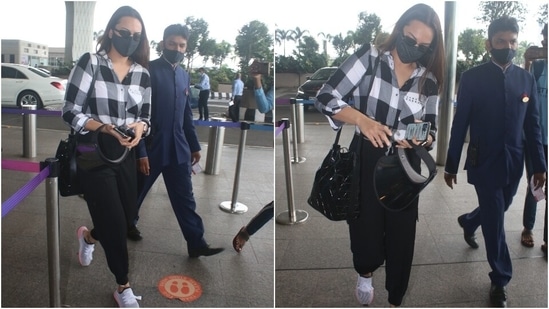 Sonakshi was snapped at the airport in a black and white check-print collared shirt with button-up details and a front knot. She teamed the long-sleeved shirt with high-waist black joggers that had gathered hems. (Varinder Chawla)