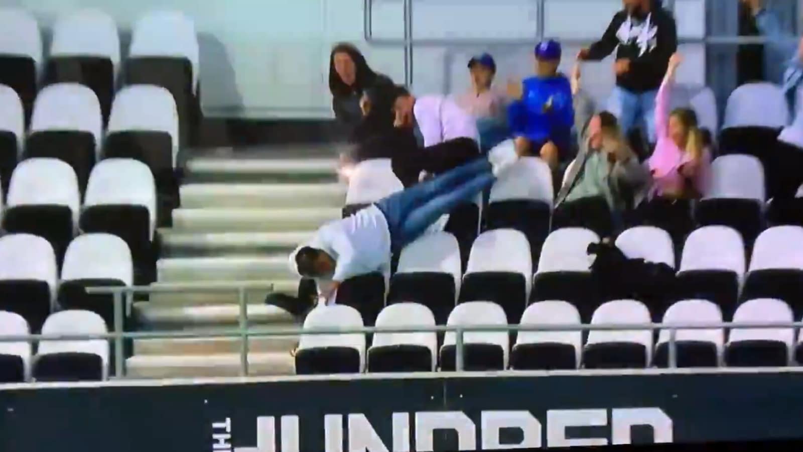 Fan falls over empty seats while catching Livingstone's massive six, manages to save his phone - VIDEO