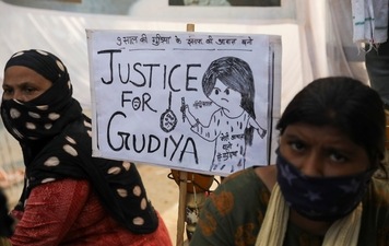 Women sit next to a placard near a crematorium where people are protesting against the alleged rape and murder of a 9-year-old girl in New Delhi. (REUTERS) Women sit next to a placard near a crematorium where people are protesting against the alleged rape and murder of a 9-year-old girl in New Delhi. (REUTERS)