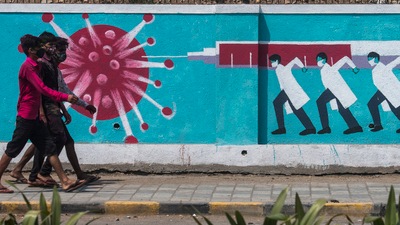 People walk past a wall mural depicting medical staff as frontline Covid-19 warriors in Mumbai. (Pratik Chorge/HT Photo)