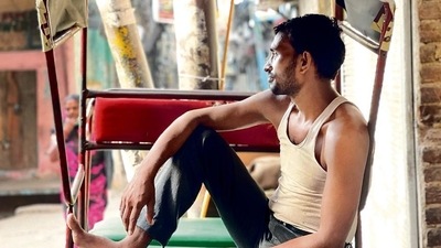 This morning, the rickshaw puller has parked his rickshaw on a street-side in central Delhi, close to where he sleeps. Wearing pants and a baniyan, he is leisurely perched on the passenger’s seat, smoking a beedi. (Mayank Austen Soofi) This morning, the rickshaw puller has parked his rickshaw on a street-side in central Delhi, close to where he sleeps. Wearing pants and a baniyan, he is leisurely perched on the passenger’s seat, smoking a beedi. (Mayank Austen Soofi)