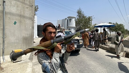 A Taliban fighter holds a rocket propelled grenade as he stands guard at an entrance gate outside the interior ministry in Kabul.(AFP)