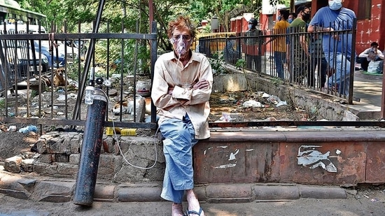 A Covid-19 patient on oxygen support waits outside Lok Nayak Hospital in April. The city’s health care system crumbled under the pressure of an unprecedented rise in Covid cases in April-May, and shortage of medicines and oxygen.( Ajay Aggarwal /HT PHOTO) A Covid-19 patient on oxygen support waits outside Lok Nayak Hospital in April. The city’s health care system crumbled under the pressure of an unprecedented rise in Covid cases in April-May, and shortage of medicines and oxygen.( Ajay Aggarwal /HT PHOTO)
