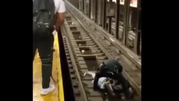 The image shows the NYPD officer helping the passenger.