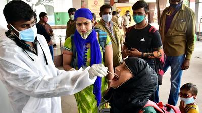 A healthcare worker collects a swab sample from a passenger for Covid-19 test at city railway station in Bengaluru on Thursday. (ANI) A healthcare worker collects a swab sample from a passenger for Covid-19 test at city railway station in Bengaluru on Thursday. (ANI)