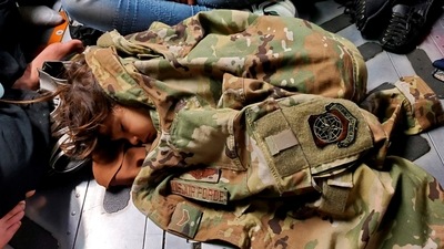 An Afghan child sleeps on the cargo floor of a US Air Force C-17 Globemaster III, kept warm by the uniform of Airman First Class Nicolas Baron, C-17 loadmaster, during an evacuation flight from Kabul, Afghanistan, (Reuters)