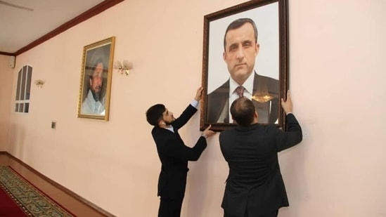 Afghan embassy staff hang a portrait of Afghan First Vice President Amrullah Saleh, who declared himself the "legitimate caretaker president", on the wall at the embassy in Dushanbe, Tajikistan. 