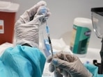 A health care worker fills a syringe with the Pfizer Covid-19 vaccine in New York, US. A health care worker fills a syringe with the Pfizer Covid-19 vaccine in New York, US.