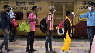 A healthcare worker checks temperature of commuters arriving from outstation trains at Dadar station in Mumbai on Friday. (Satish Bate/HT PHOTO) A healthcare worker checks temperature of commuters arriving from outstation trains at Dadar station in Mumbai on Friday. (Satish Bate/HT PHOTO)