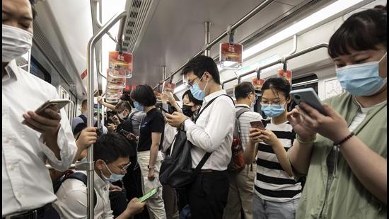 Passengers use their smartphones while riding a subway train in Shanghai, China. (Bloomberg)