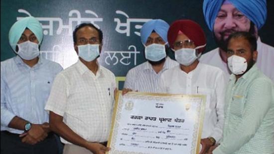 Fatehgarh Sahib member of parliament (MP) Dr Amar Singh and deputy commissioner Varinder Kumar Sharma launching the debt relief scheme for the farm labourers and landless farmers in Ludhiana on Friday. (HT photo)