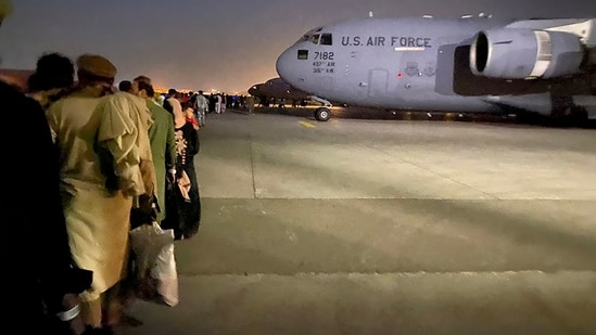 Afghans queue up and board a US military aircraft in Kabul after the Taliban's takeover of Afghanistan. (AFP Photo)