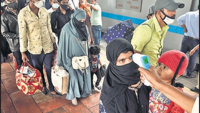 A BMC health worker checks temperature before Covid-19 test of commuters arriving from outstation trains at Dadar station, in Mumbai, on Saturday. (Satish Bate/HT Photo) A BMC health worker checks temperature before Covid-19 test of commuters arriving from outstation trains at Dadar station, in Mumbai, on Saturday. (Satish Bate/HT Photo)