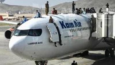 There is a mad scramble as people desperate to leave Afghanistan climb atop air planes in Kabul fearing Taliban’s hardline Islamist rule. (AFP Photo)