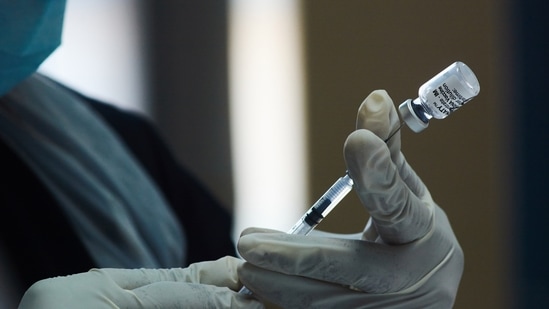 A health worker prepares a dose of the Pfizer-BioNTech Covid-19 vaccine. (Waldo Swiegers / BLOOMBERG)