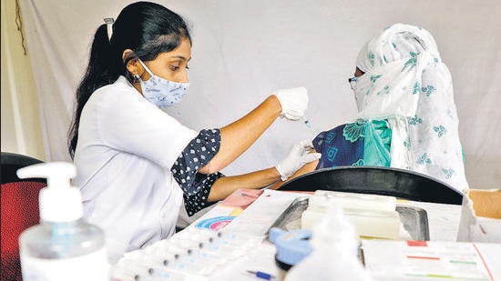 A health worker administers the Covid-19 vaccine to a beneficiary at a vaccination centre in Katraj on Friday. (HT PHOTO)