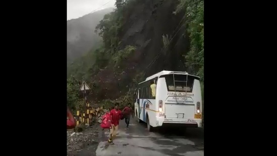 The passengers are seen running away from the landslide site in Nainital on Friday. (ANI Photo)
