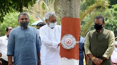 Bihar CM Nitish Kumar ties rakhis to trees in Patna on the occasion of Rakshabandhan on Sunday. (Santosh Kuma/HT)