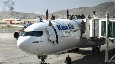 Afghan people climb atop a plane as they wait at the Kabul airport on August 16 (AFP) Afghan people climb atop a plane as they wait at the Kabul airport on August 16 (AFP)
