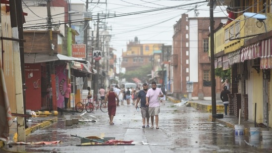 Residents walk past debris after Hurricane Grace made landfall in Tecolitla, Veracruz state in Mexico, on Saturday, August 21.(Bloomberg)
