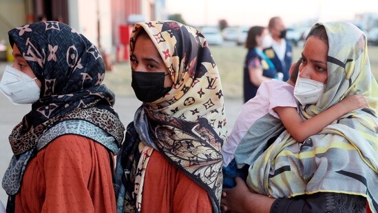 Afghan women queue upon their arrival aboard a second evacuation airplane, carrying Afghan collaborators and their families, that landed at the Torrejon de Ardoz air base, 30 km away from Madrid. (AFP)