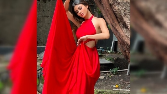 These photos of Mouni Roy clicked in a red halter dress was captured in front of a rustic backdrop under a tree.(Instagram/@mouniroy)
