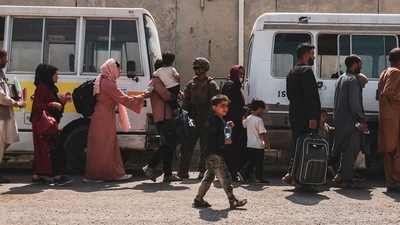 Evacuees load on to buses to be processed during an evacuation at Hamid Karzai International Airport, Kabul, Afghanistan. (AFP) Evacuees load on to buses to be processed during an evacuation at Hamid Karzai International Airport, Kabul, Afghanistan. (AFP)