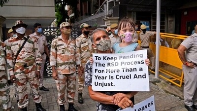 An Afghan living in Delhi carries his daughter and holds placards during a protest outside the UNHCR office (United Nation High Commissioner for Refugees) in New Delhi on August 23. (AP) An Afghan living in Delhi carries his daughter and holds placards during a protest outside the UNHCR office (United Nation High Commissioner for Refugees) in New Delhi on August 23. (AP)
