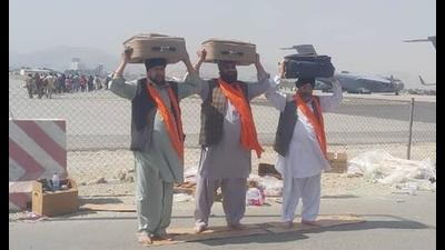 Three Afghan Sikhs carrying the Guru Granth Sahib from different gurdwaras in Afghanistan at the Kabul airport before their departure to India. (PTI)