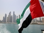 UAE flag flies over a boat at Dubai Marina.