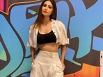 Mouni Roy channels her inner sass and slays the street style trend in a black strap crop top, white crop shirt-like shrug and a pair of white trousers.(Instagram/imouniroy)